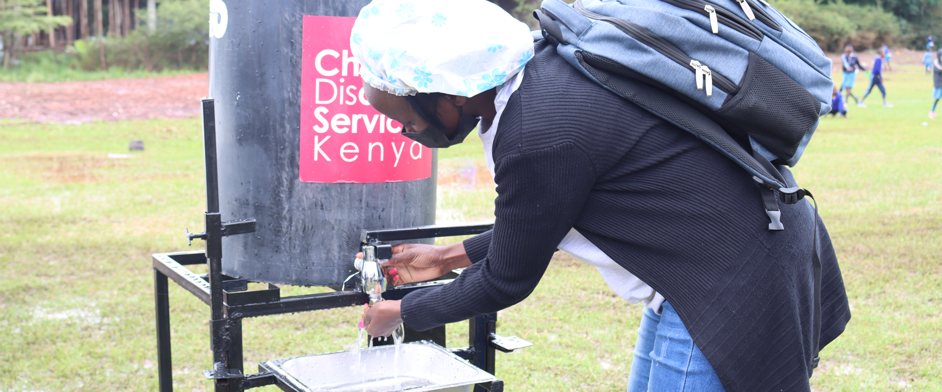 A participant washing hands using the hand washing equipment donated by CDSK during the International Day for persons with disabilities.