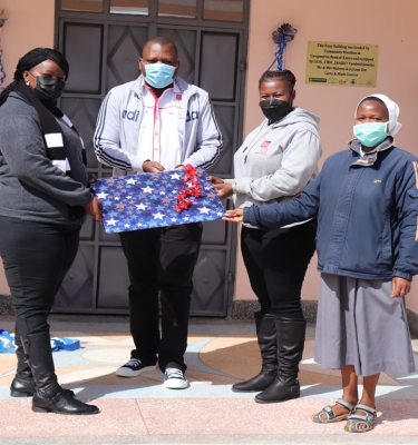 Cecilia Mutava receiving a gift from Naromoru Disabled Children’s Home